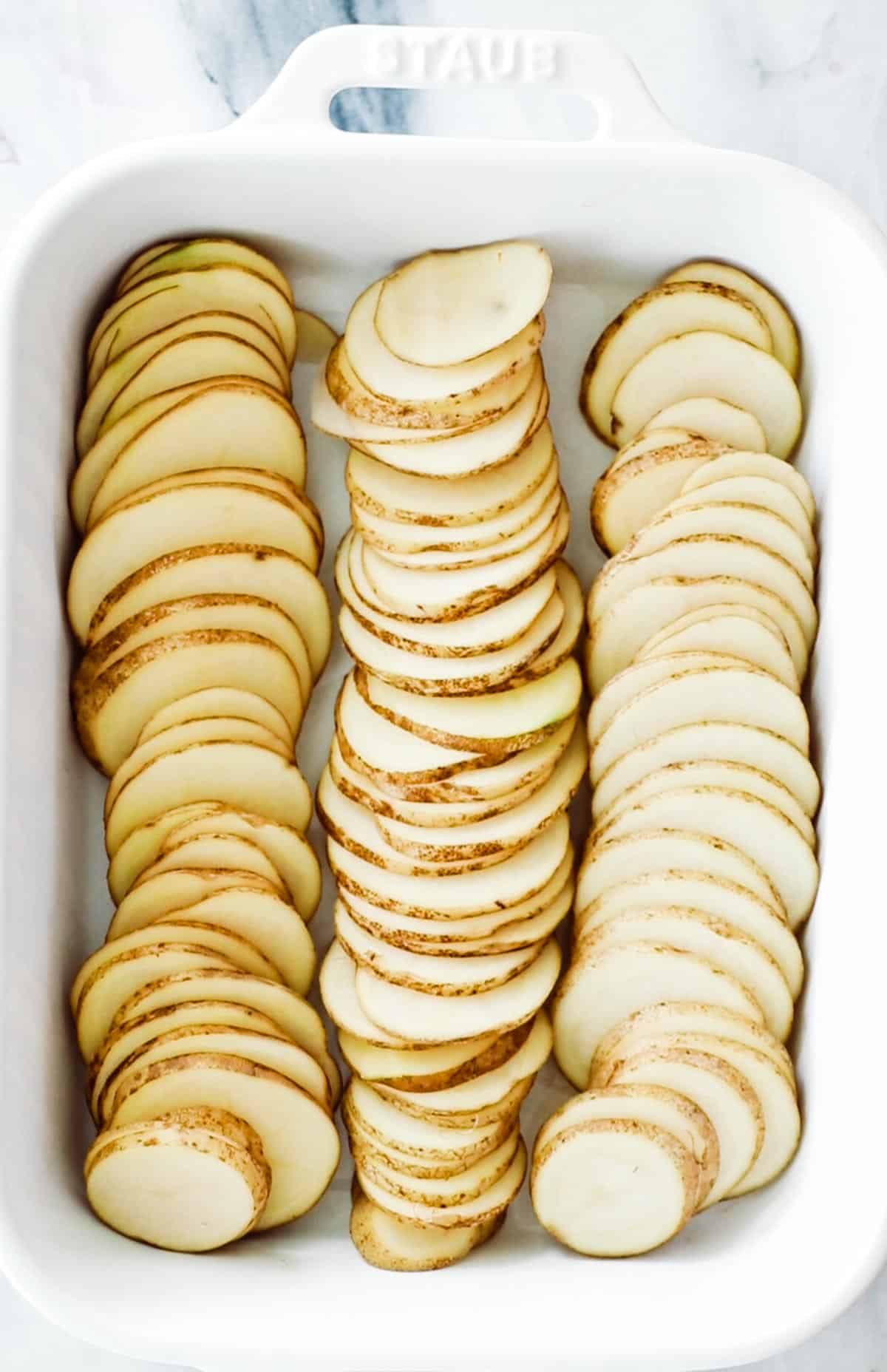 white baking pan with potatoes laid in a single later