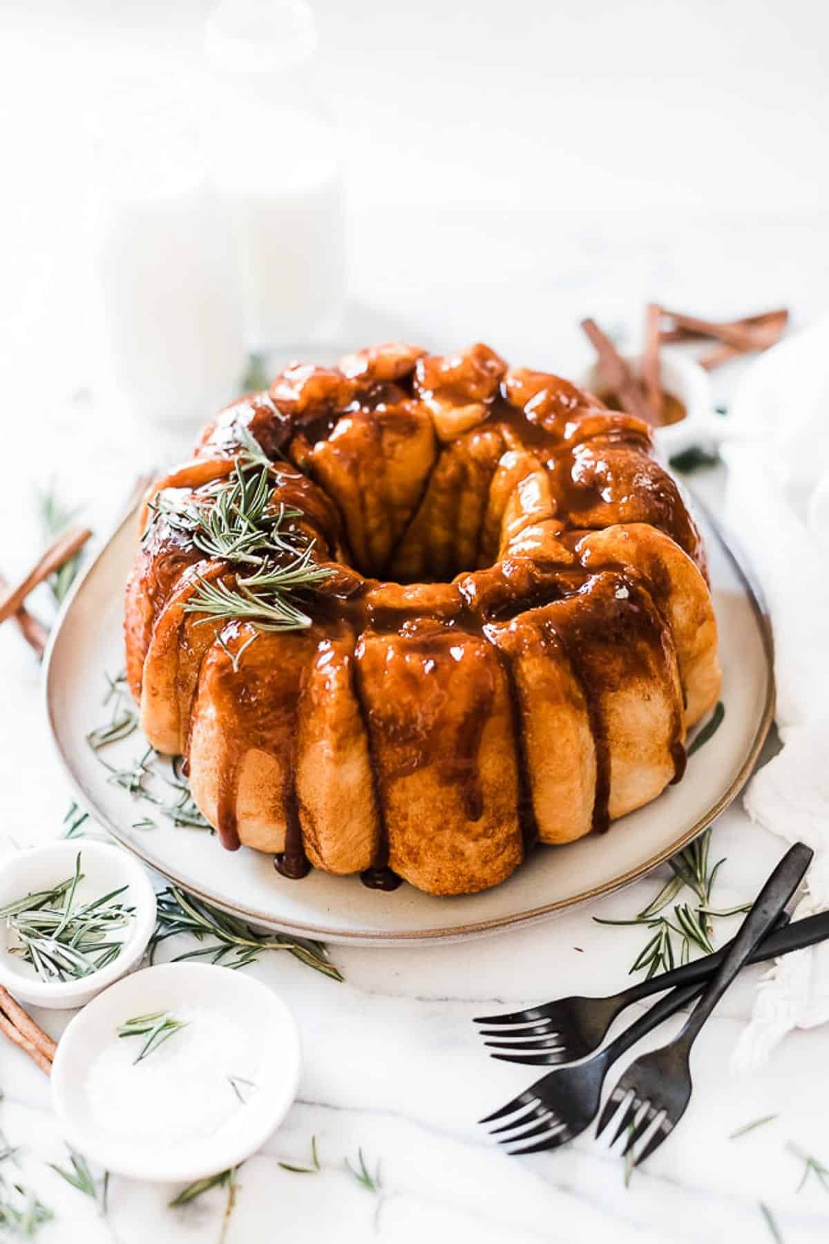Easy monkey bread recipe prepared and plated on a cream platter. There are black forks to the side.