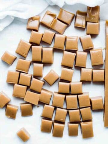 Sea salt caramels on white background cut into pieces.