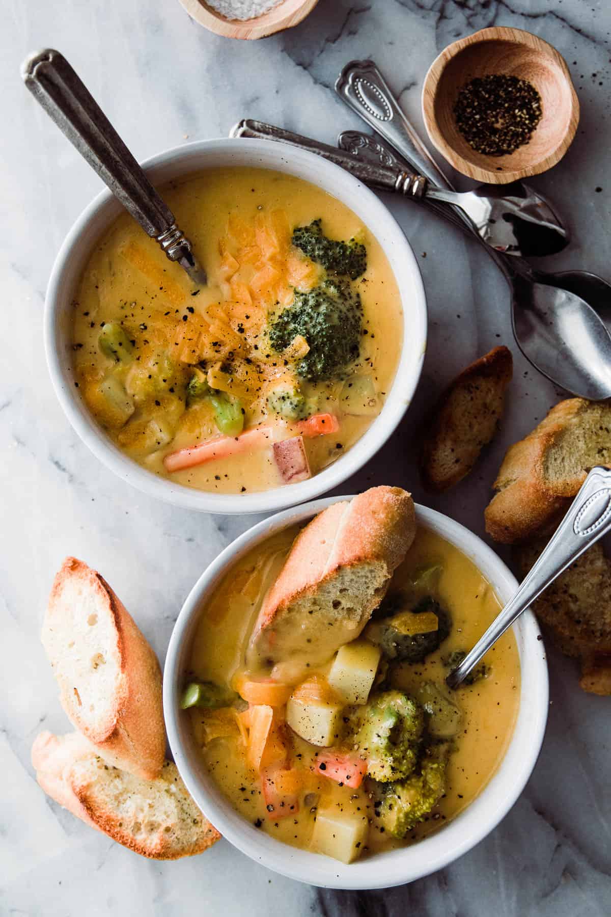 two bowls of easy broccoli cheese soup with bread
