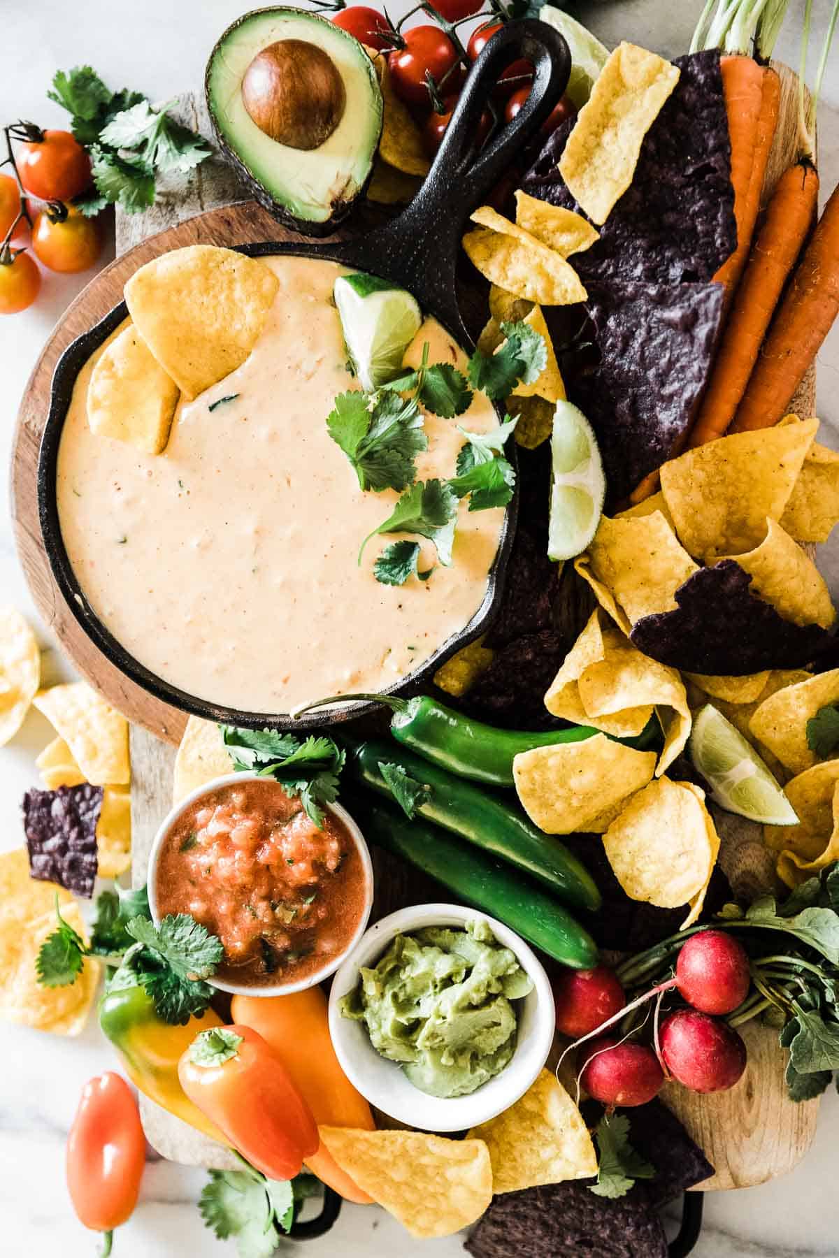 The best quest dip recipe in a small cast iron skillet surrounded by chips and veggies.