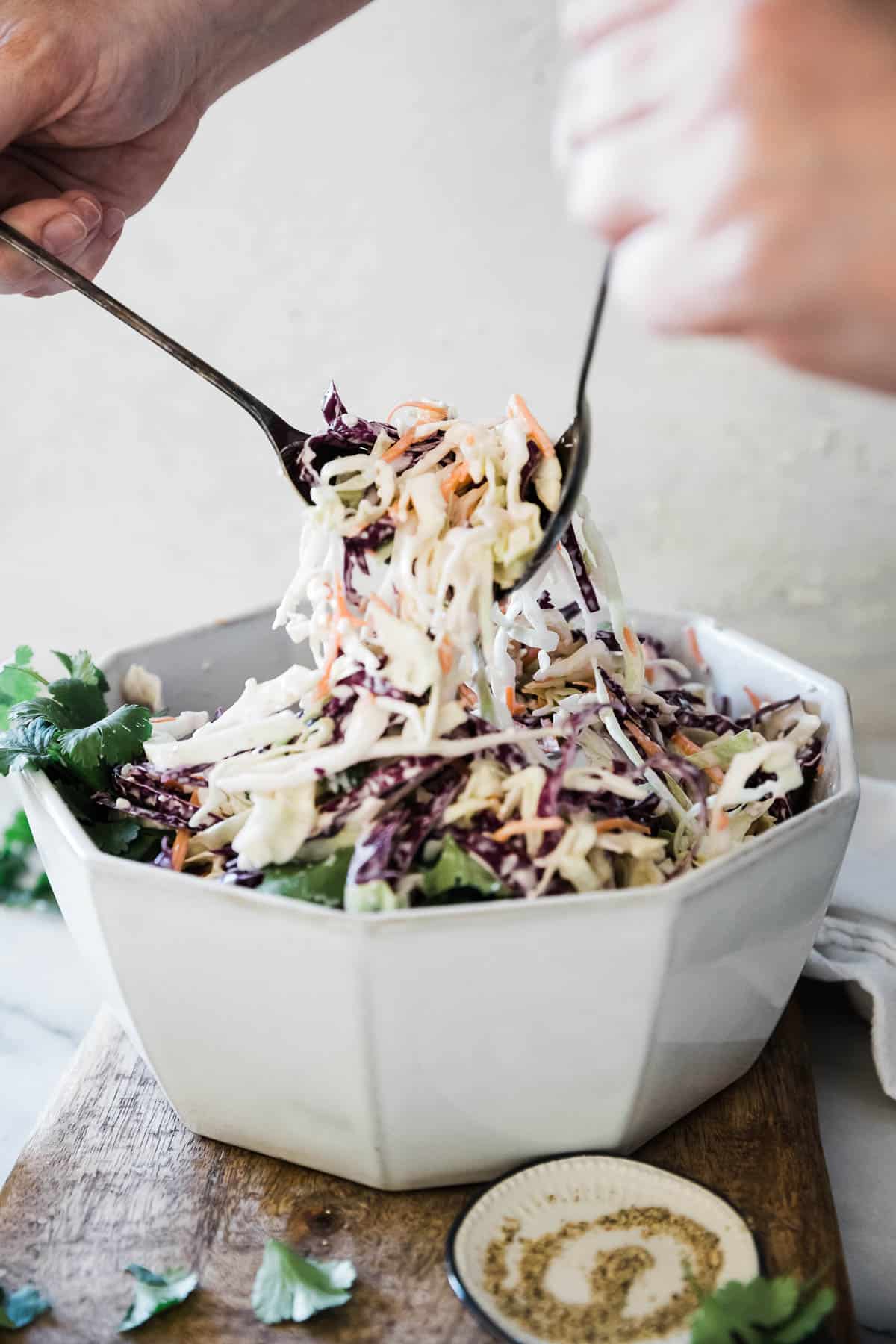 Blue cheese coleslaw being tossed.