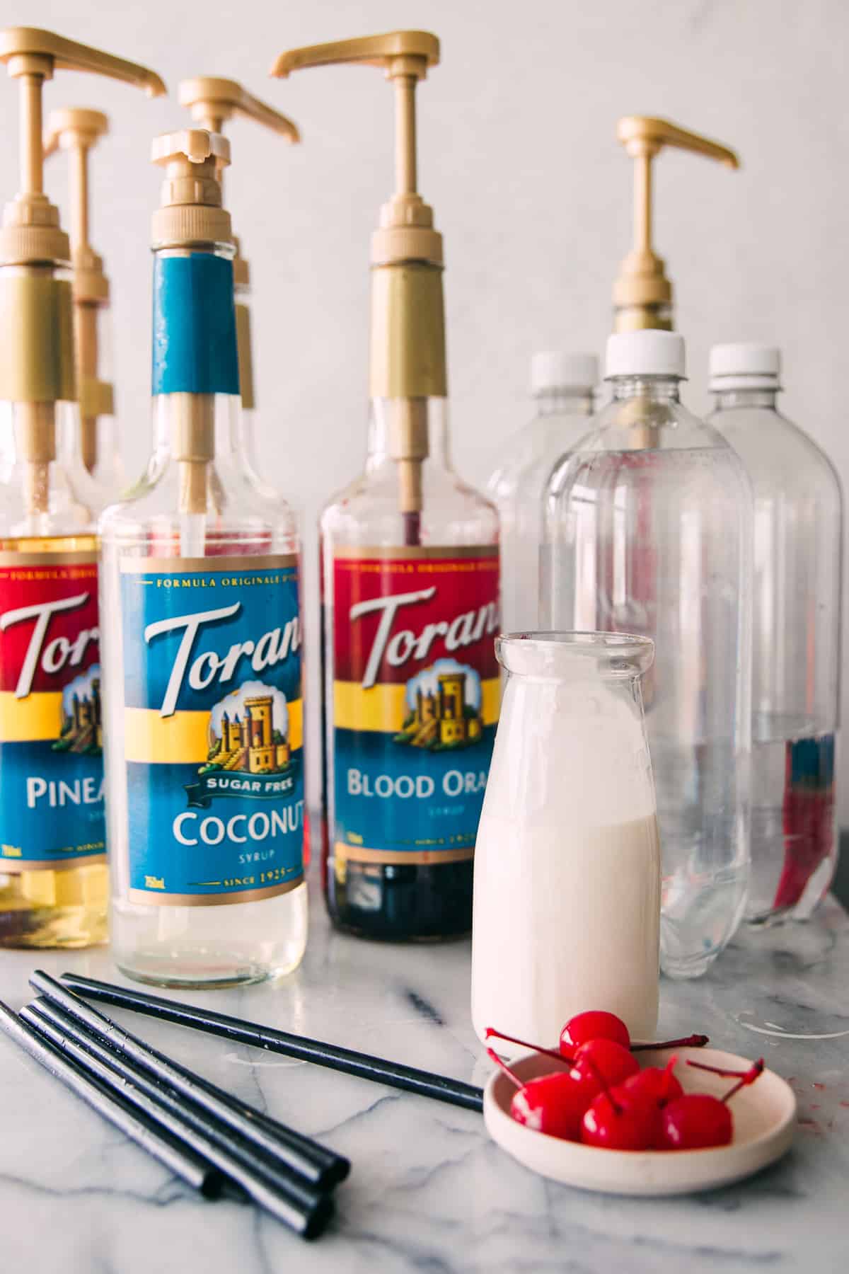 ingredients for this Italian soda recipe including heavy cream, cherries, cup soda and torani syrups 