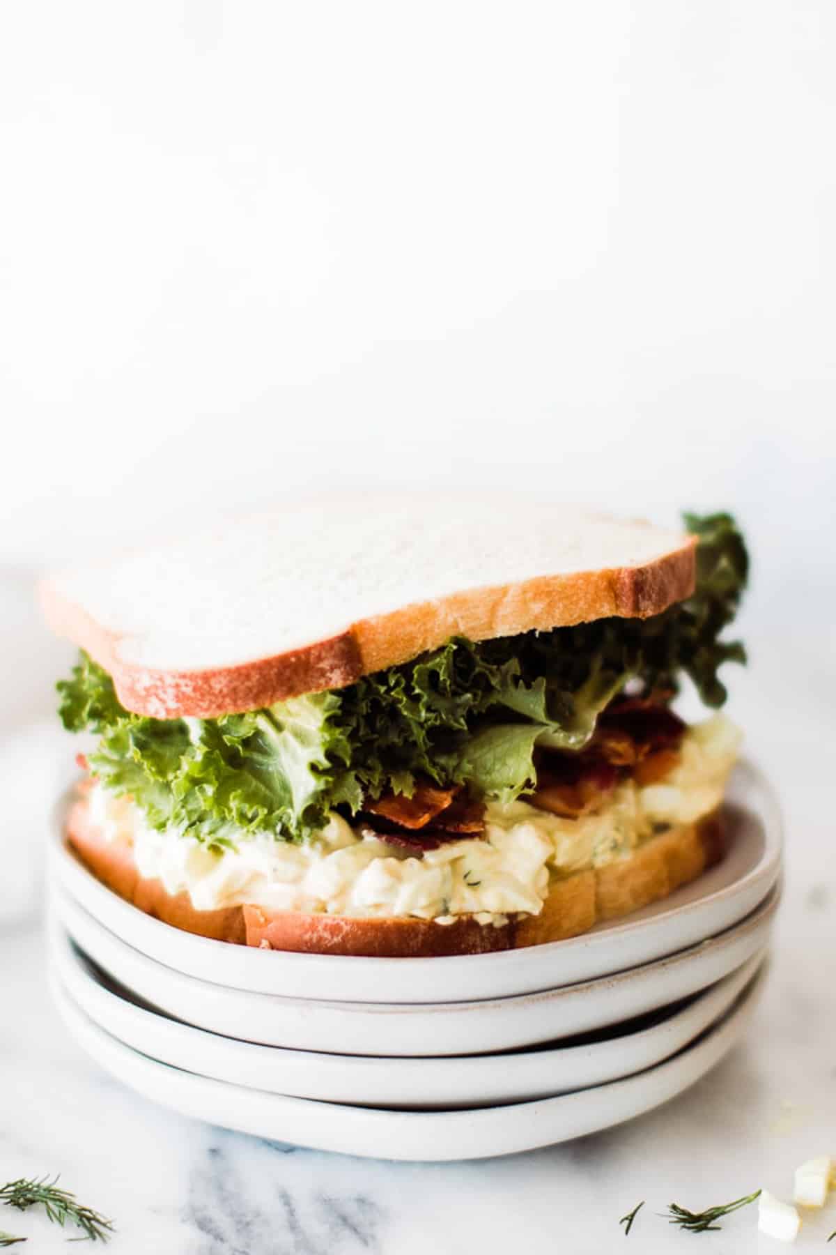 an egg salad sandwich on several plates