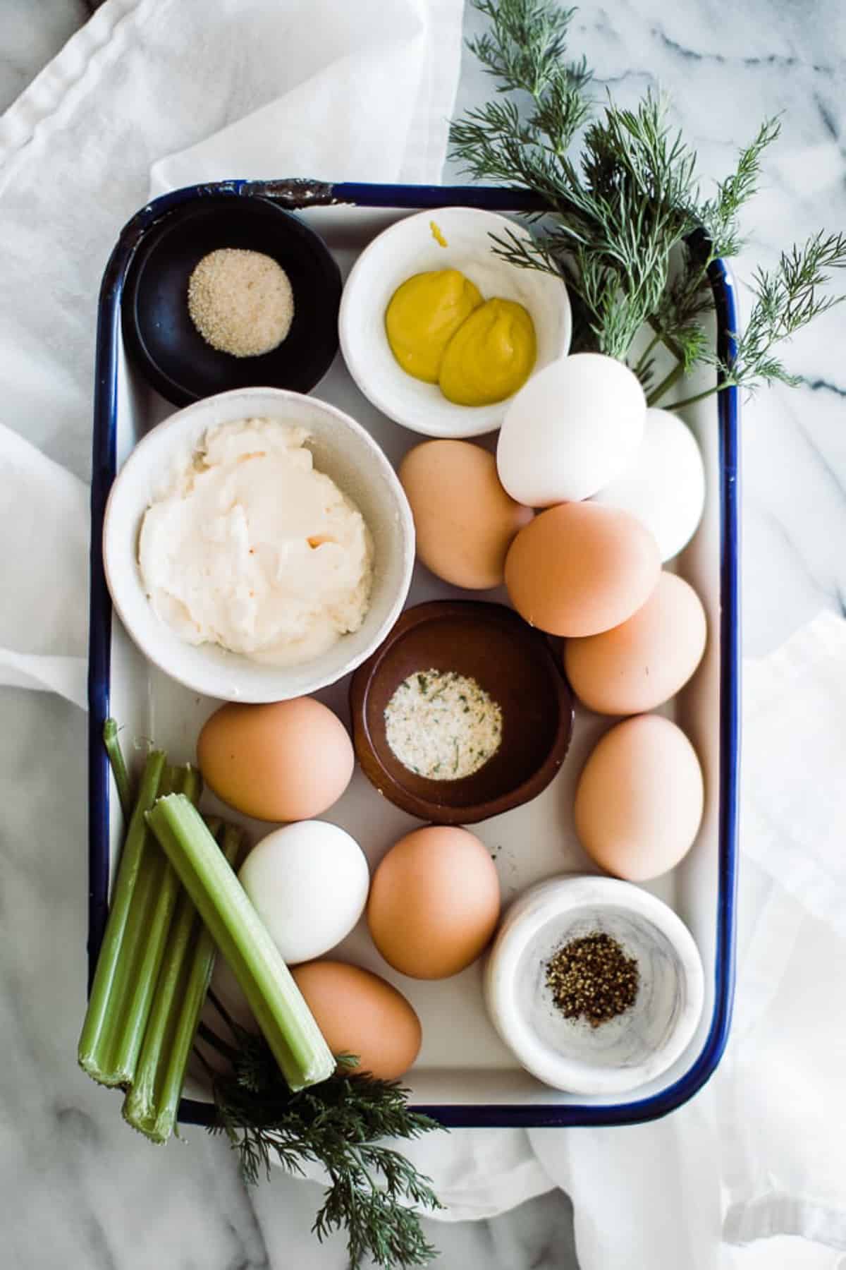 ingredients to egg salad sandwich on a tray
