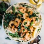 Shrimp risotto recipe in a white bowl. The dish is garnished with parsley.