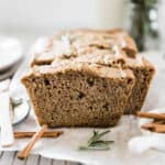Easy zucchini bread on a wire cooling rack lined with parchment paper. There are two slices cut.