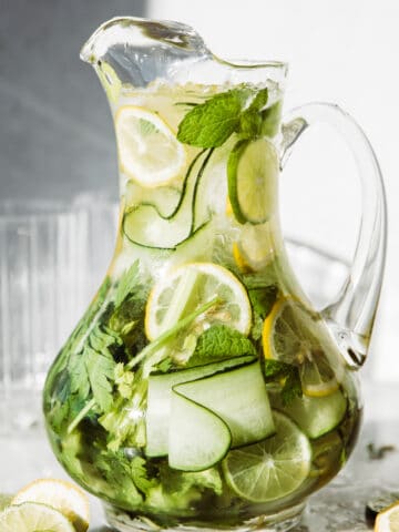 Pitcher full of cucumber, lemons and herbs.