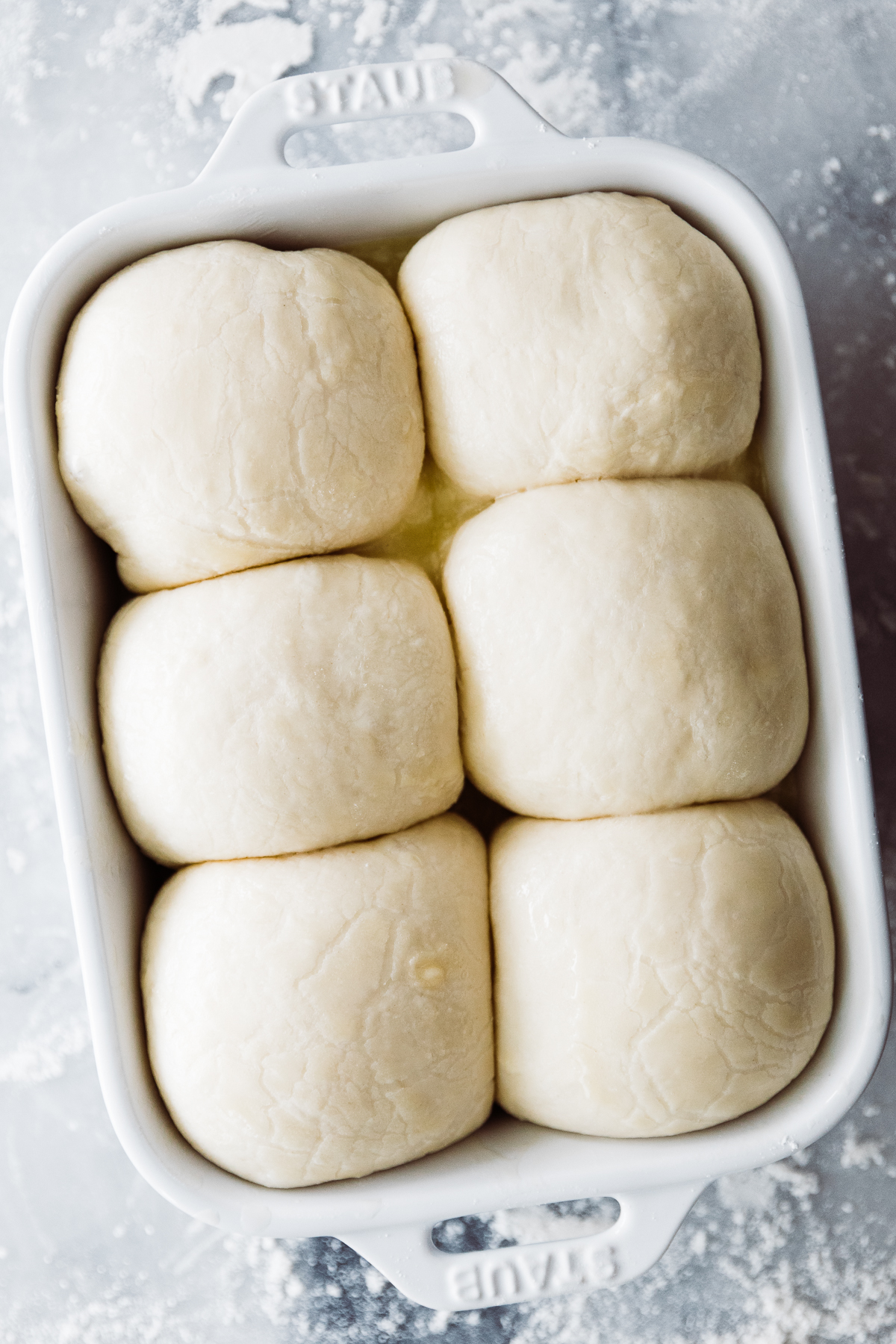 Parker house rolls rising in small pan. 