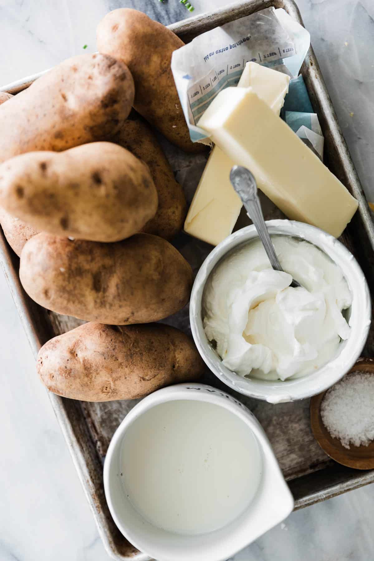 Potatoes, butter, milk, sour cream on a tray for pressure cooker mashed potatoes.