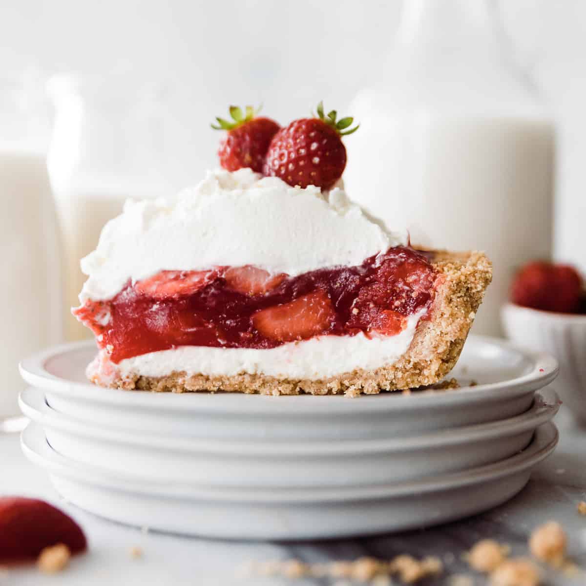 Once slice of strawberry pie with cream cheese layer, graham cracker crust and whip cream. 
