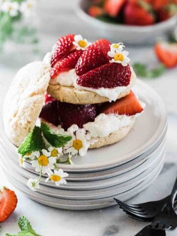 Easy strawberry shortcake on a grey plate. It is garnished with chamomile flowers.