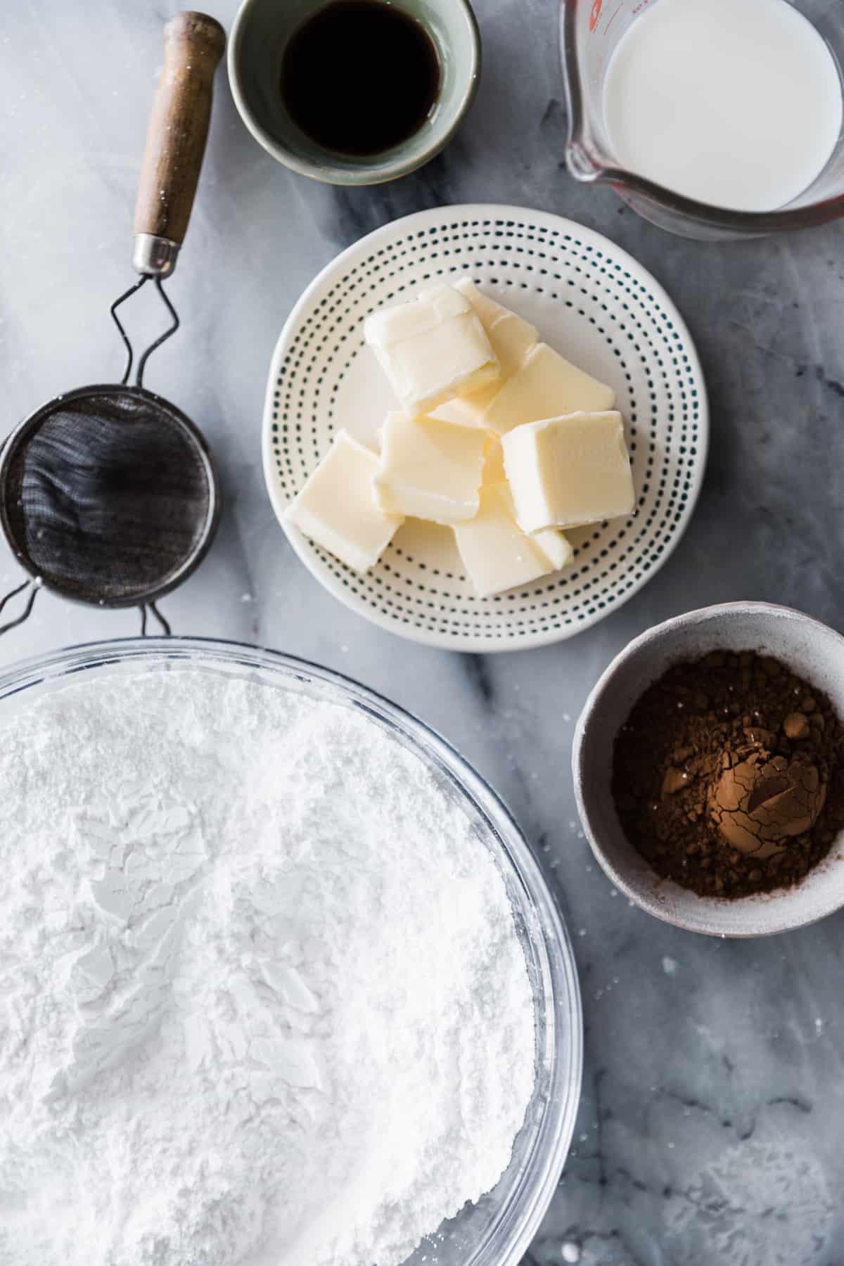 Powder sugar, butter and coco on marble counter. 