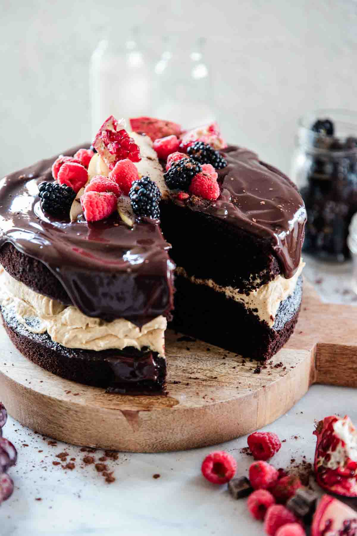 Chocolate pumpkin cake with a slice removed. The cake is garnished with fresh fruit.