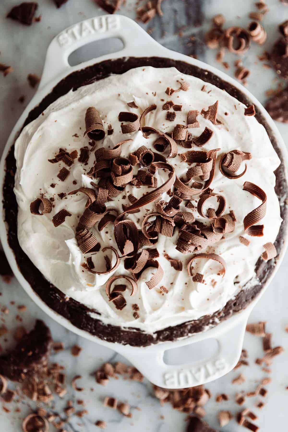 Chocolate cream pie topped with whipped cream and chocolate ribbons. 
