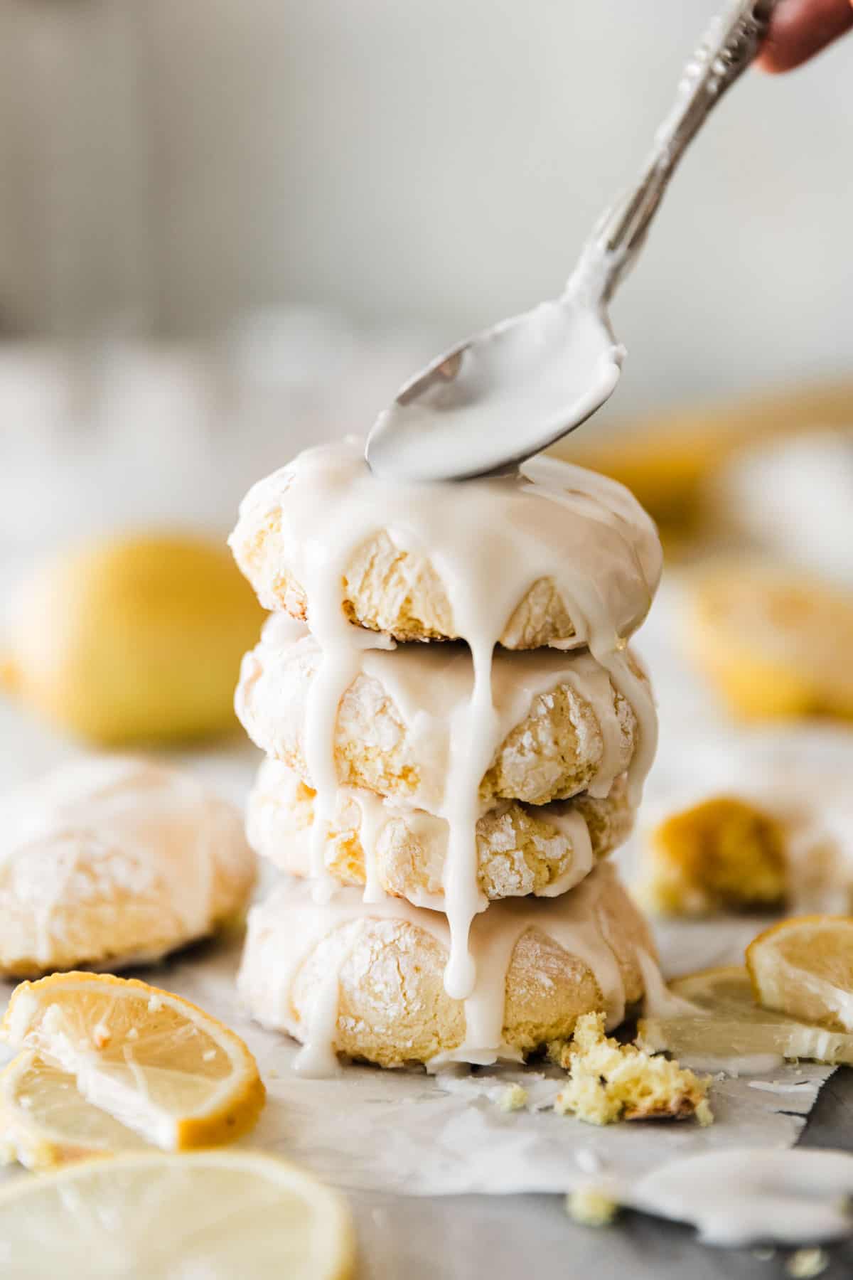 A Stack of four lemon cookies with frosting drizzling down. 