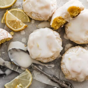Five frosted lemon cookies on a parchment paper.