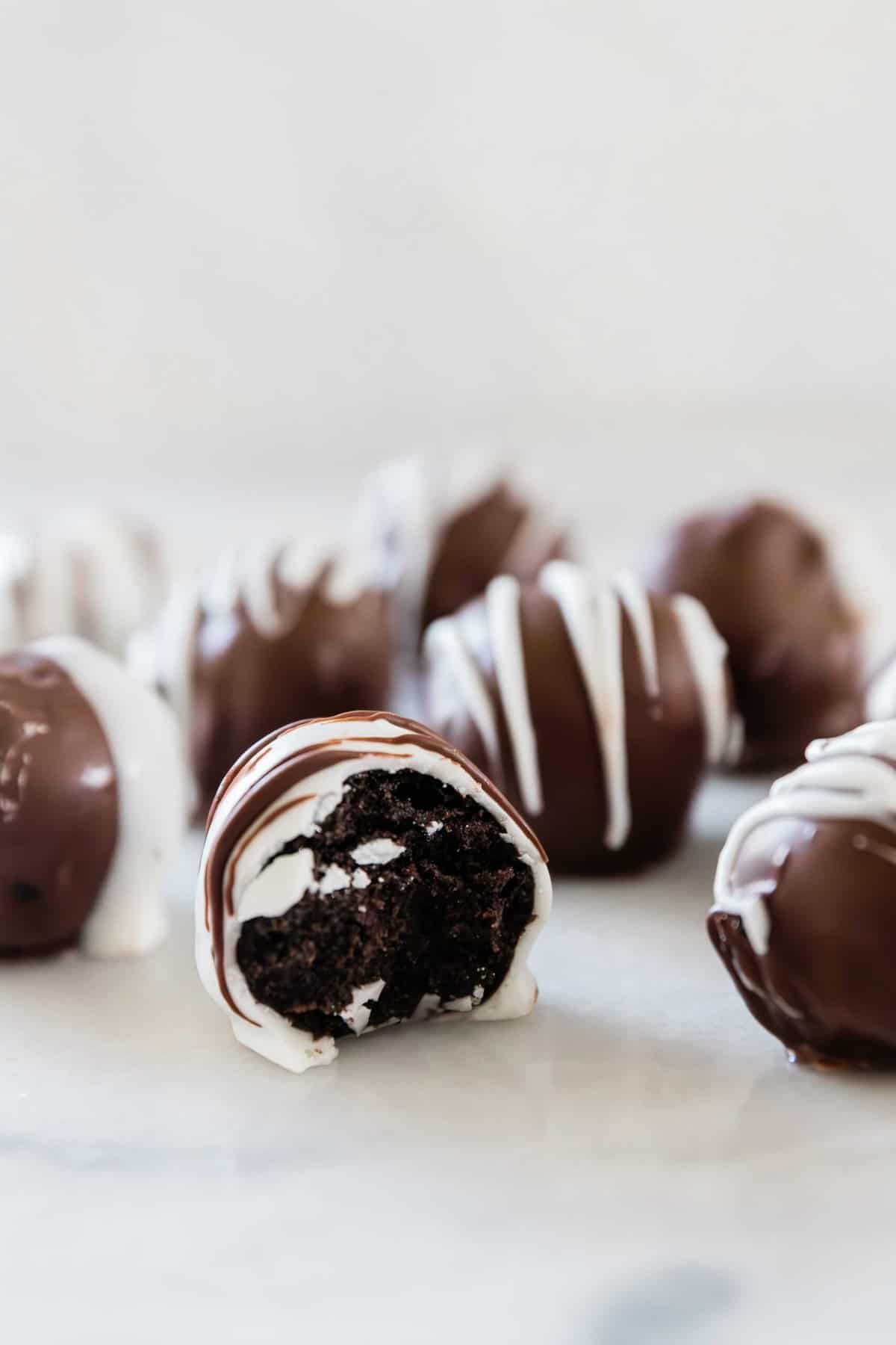 A close up of an Oreo truffle with a bite missing.