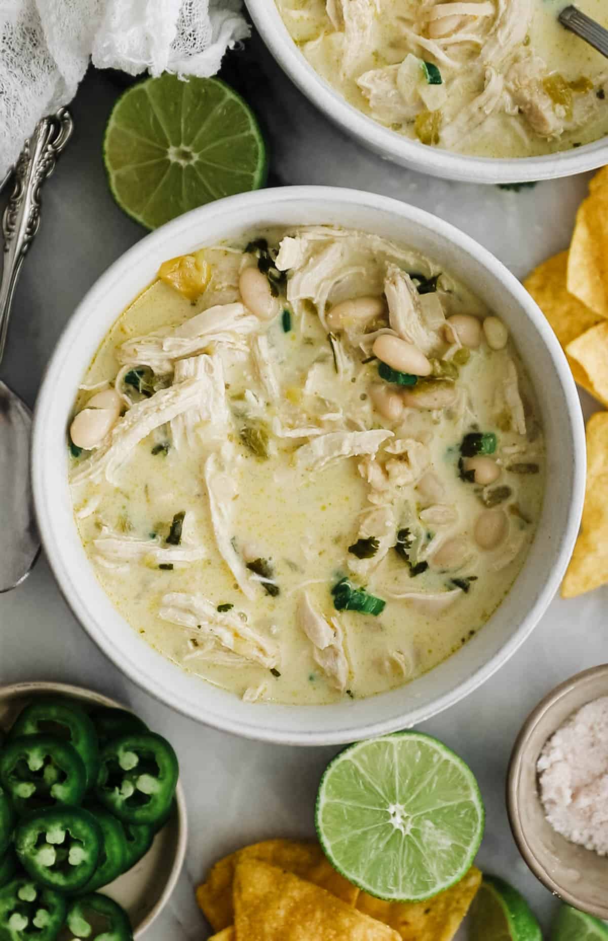 Bowl of creamy white chili with chicken, peppers and beans. 