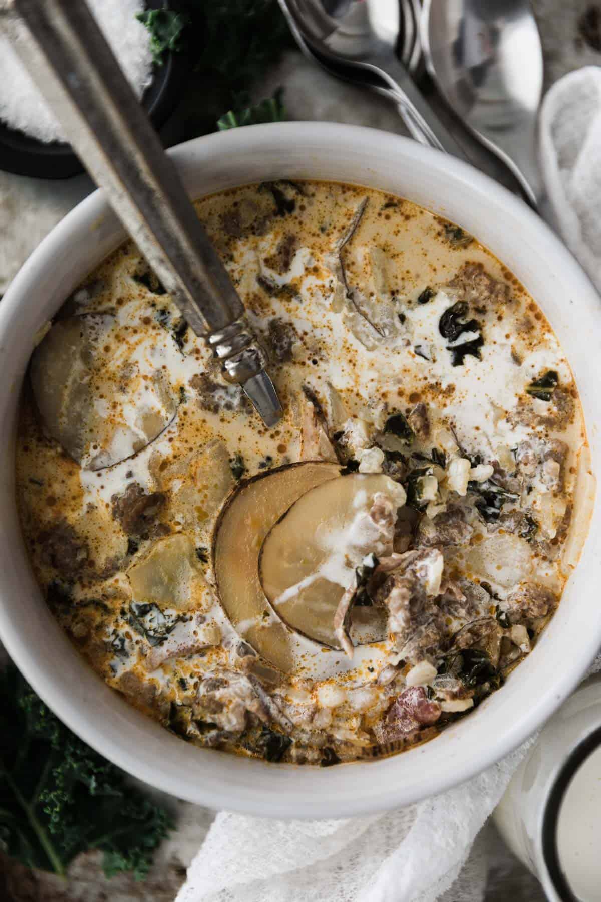 One bowl of Zuppa Toscana soup with a spoon. 