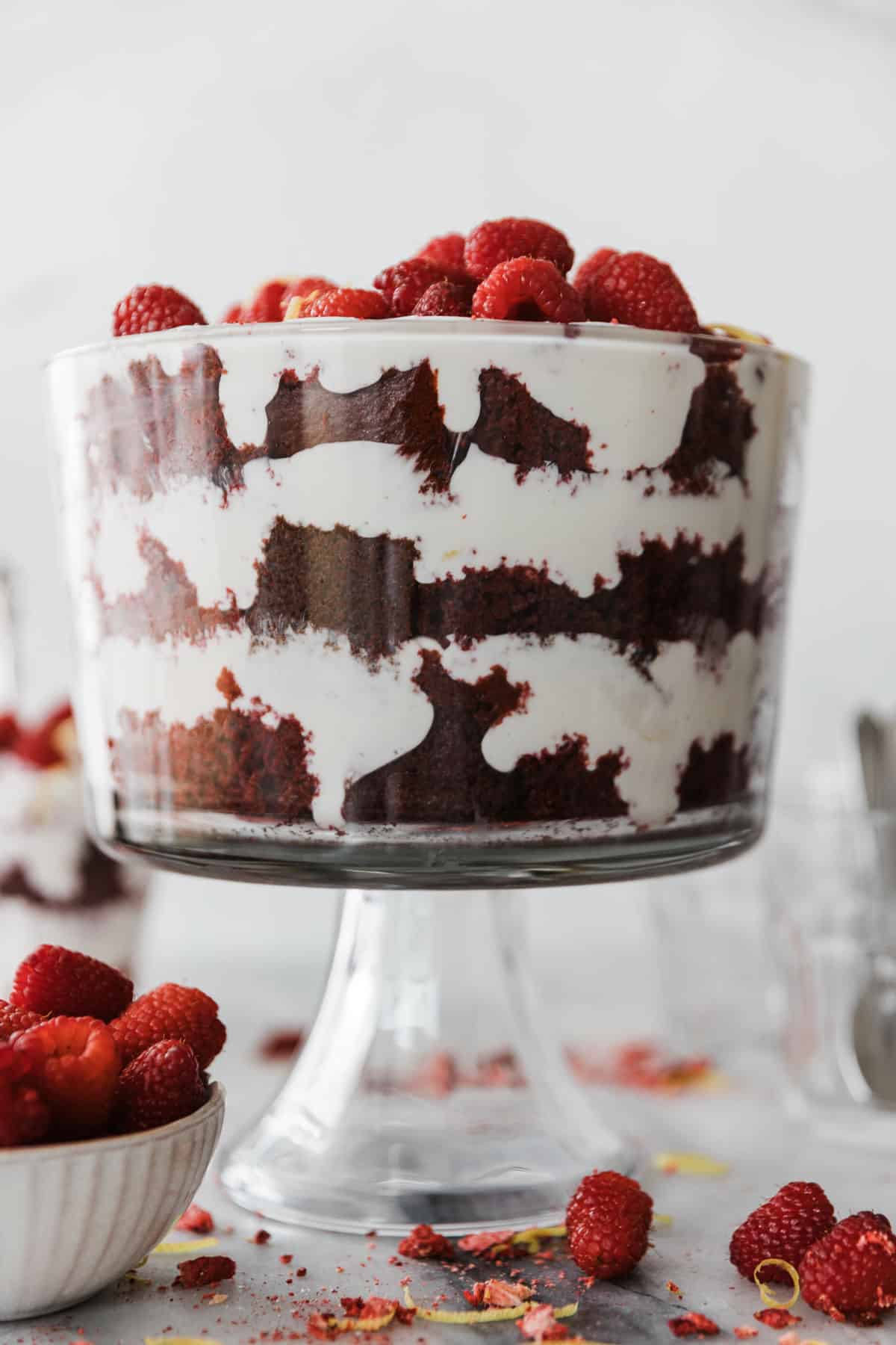Red velvet trifle bowl layered with red velvet, raspberries and cream cheese frosting. 