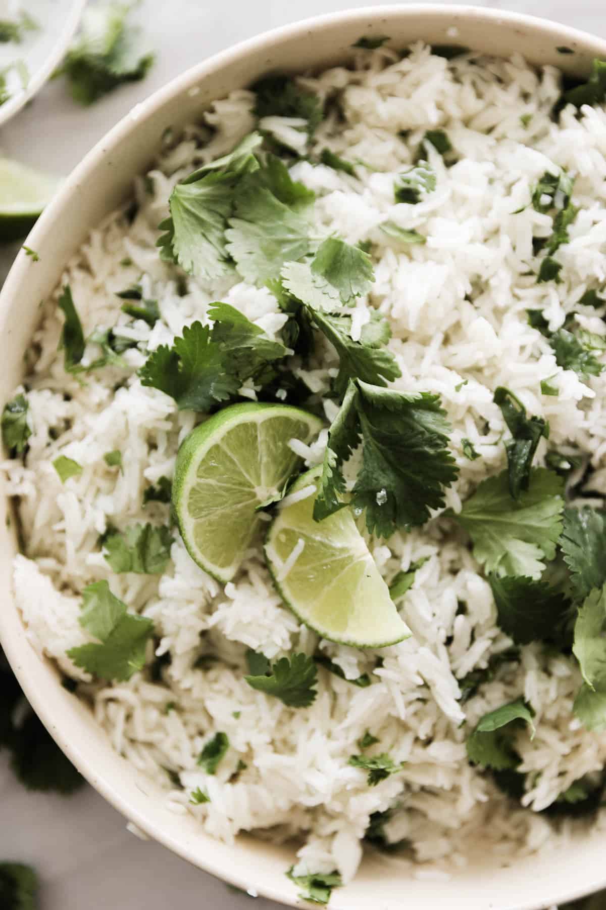 A big bowl of cilantro lime rice topped with limes.