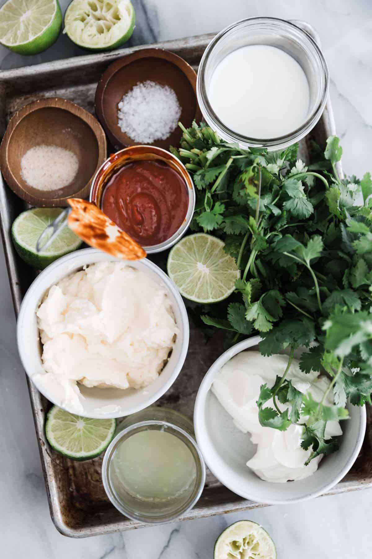 Ingredients on a tray for creamy chipotle sauce in seperate dishes.