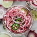 Top down photos of a jar filled with sliced red onions vinegar, spices and sliced jalapeños.