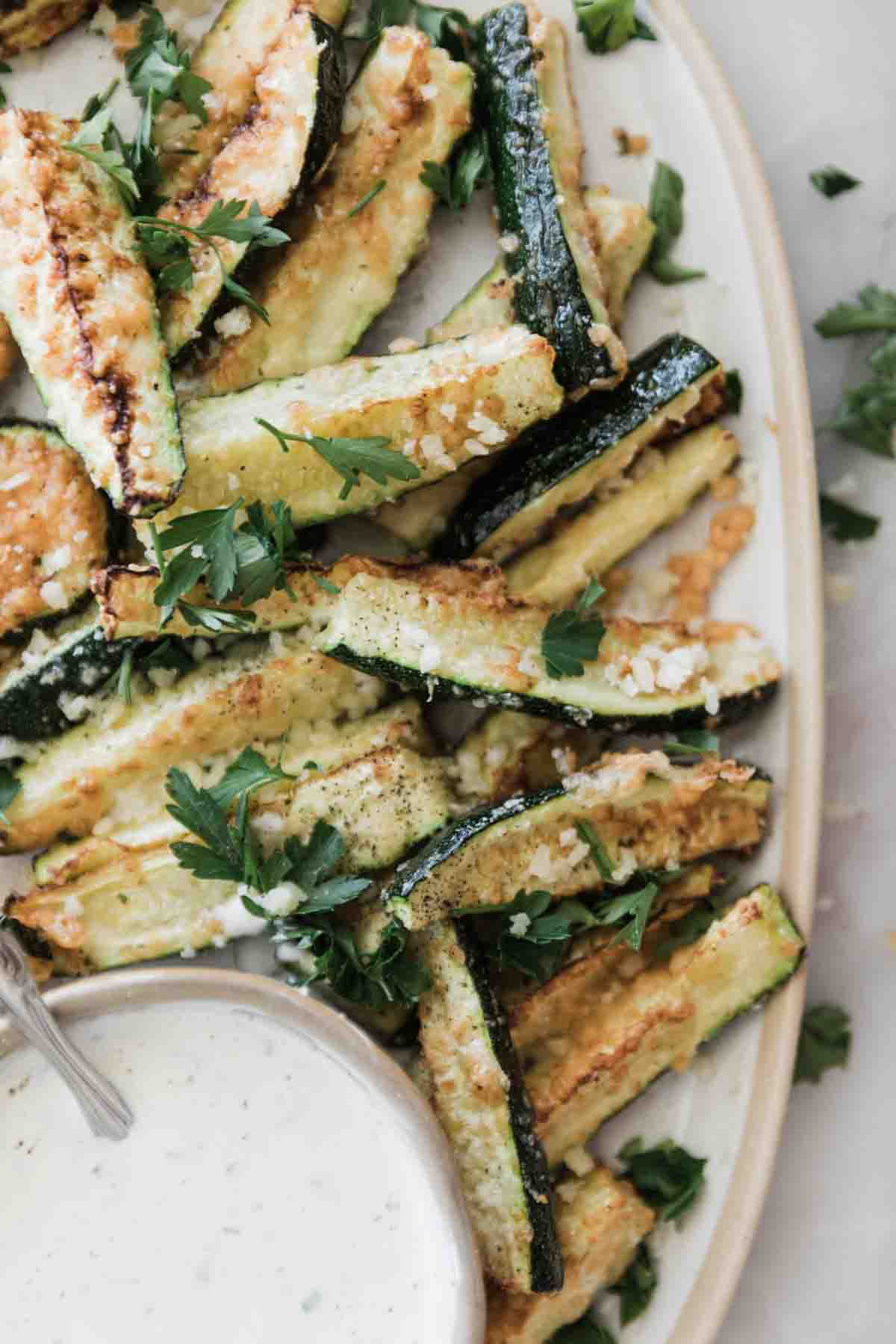 Air fryer zucchini served up on a white oval platter.