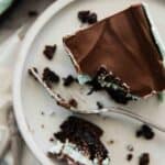 Chocolate mint brownies with one on a plate, a bite to the side, and a fork.