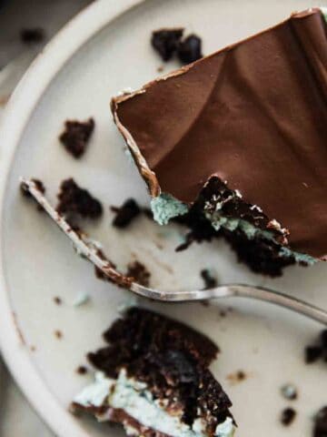 Chocolate mint brownies with one on a plate, a bite to the side, and a fork.