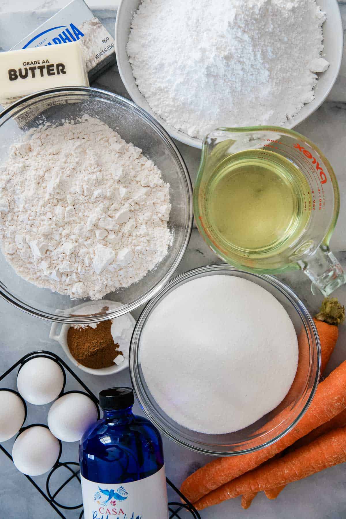 Ingredients to make carrot cake on the counter before preparing.