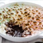 Rainbow smores dip in a white skillet.