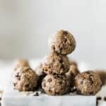 A plate of oatmeal peanut butter balls with three stacked in the middle and the rest around it.