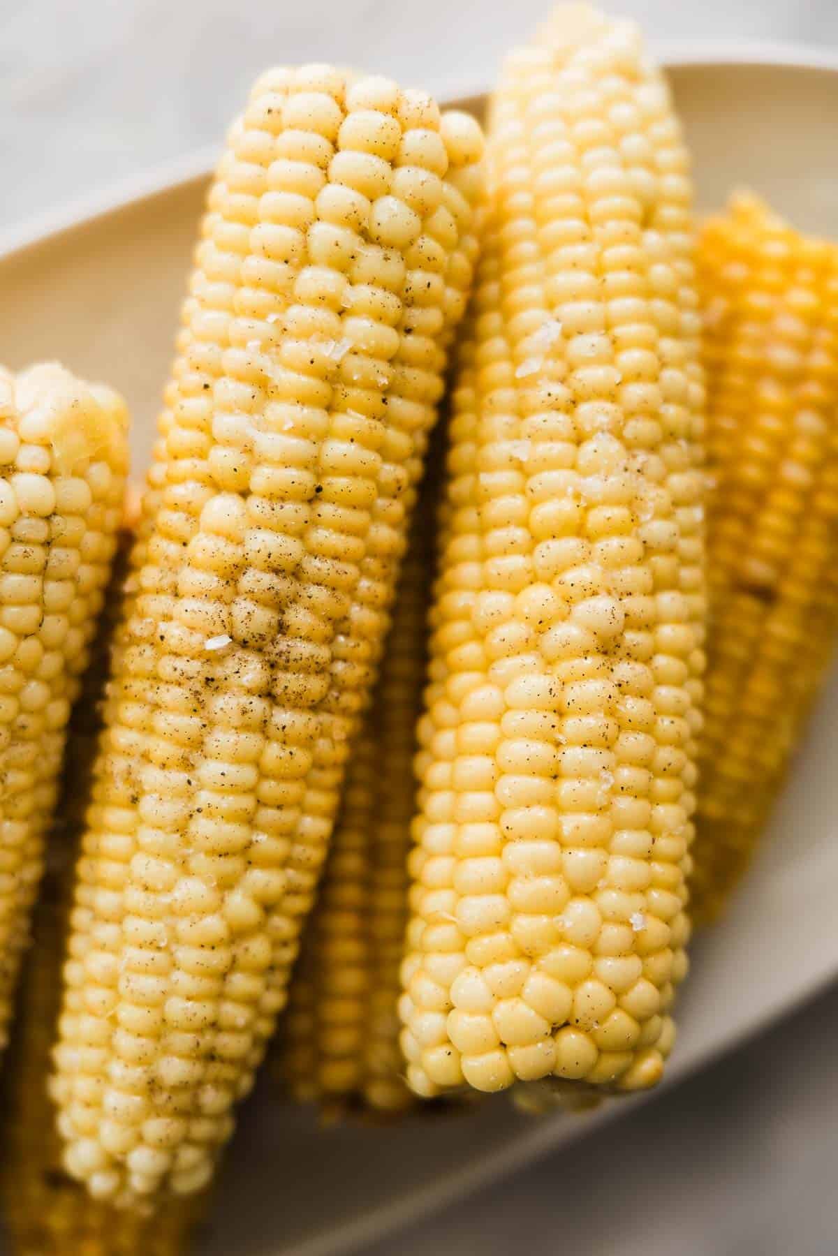 Perfectly cooked corn on the cob ears on a platter.