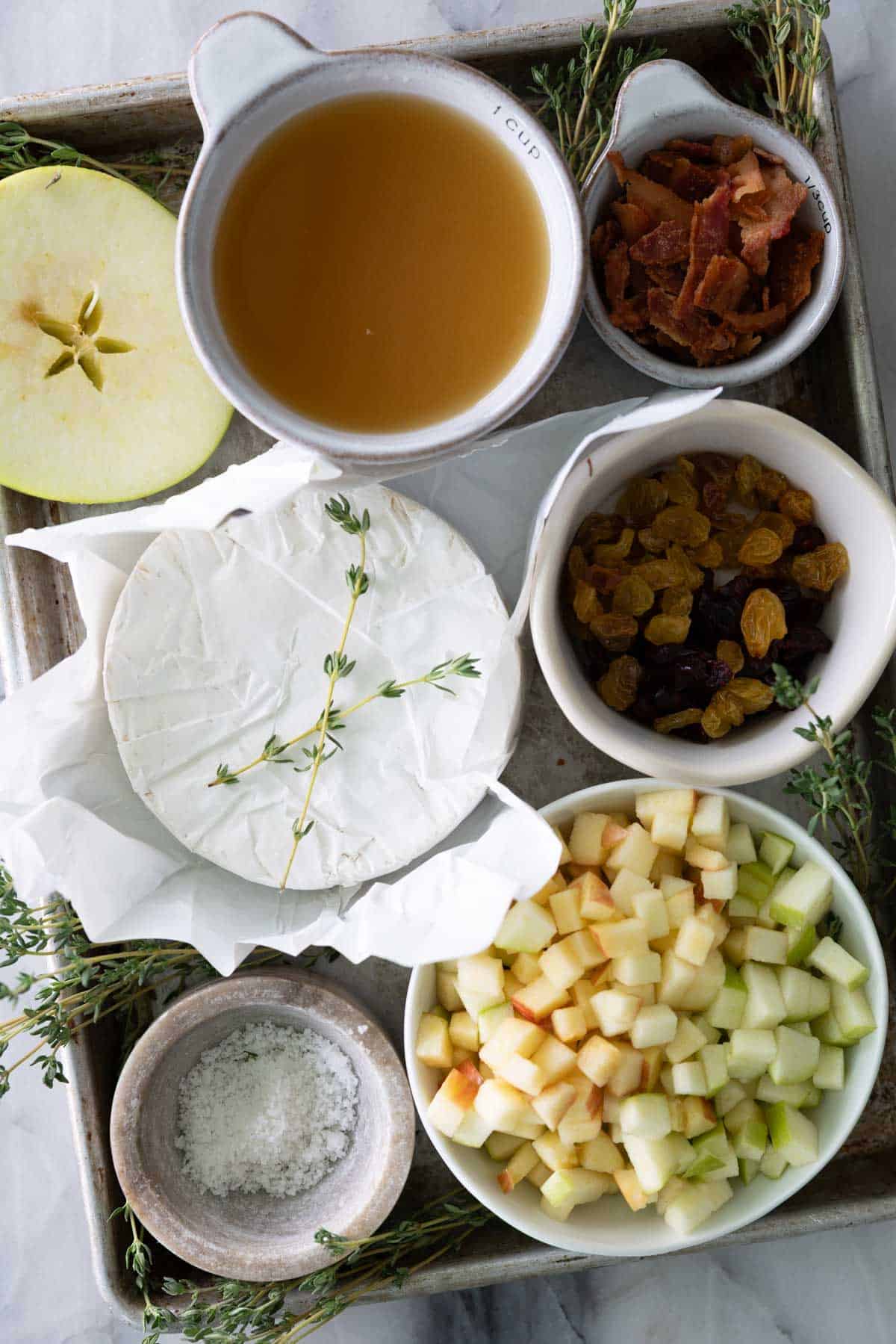 Ingredients to make a baked brie appetizer on the table in bowls.