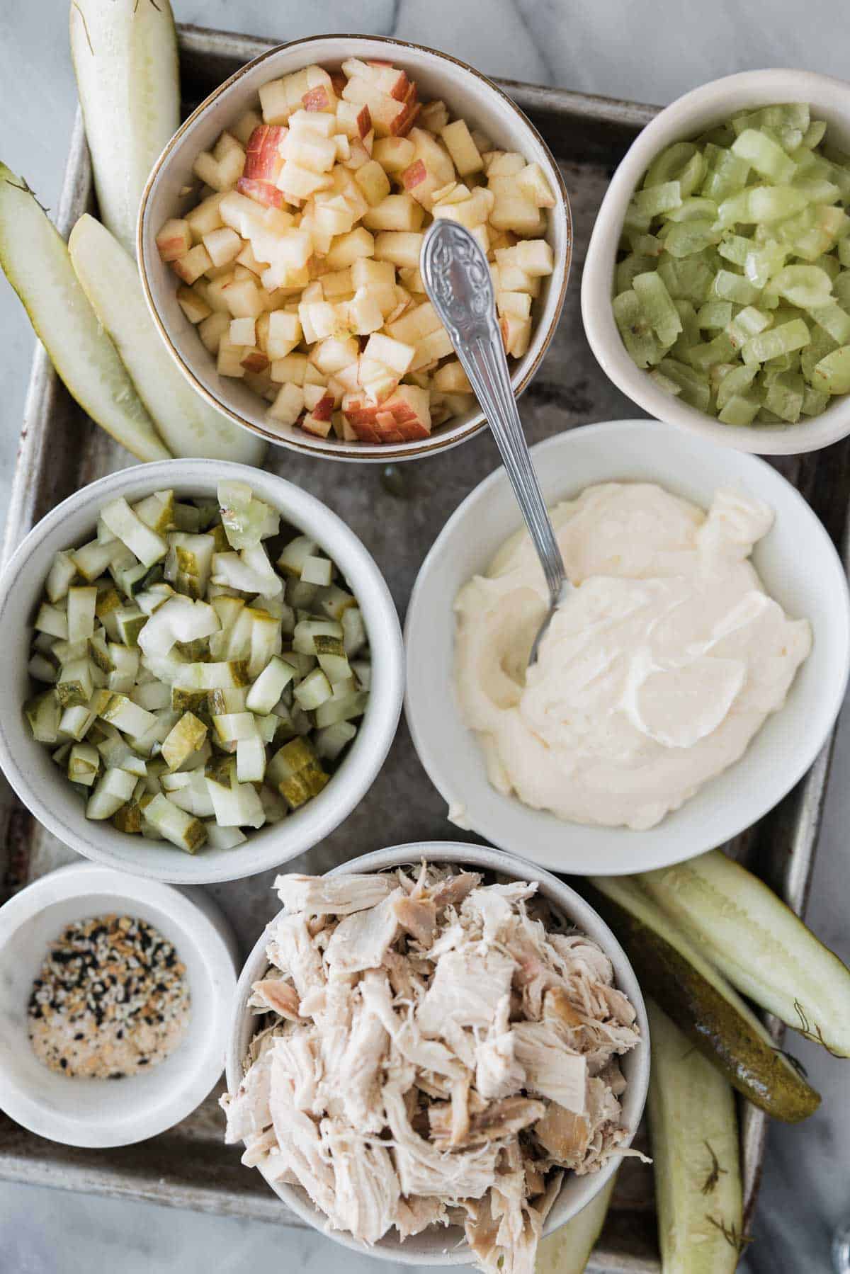 Ingredients for making dill pickle chicken salad in bowls.