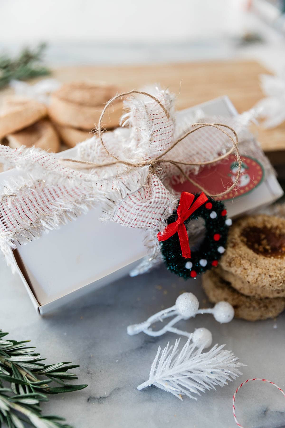 I am a big fan of pretty packaging - I love to wrap presents and I am always a sucker for a makeup item in adorable packaging, so why not package up your cookies in an inexpensive, but adorable way? I promise the receiver will be delighted to receive something so darn cute...and delicious! || Oh So Delicioso #cookies #holidaygifts #ediblegifts #giftideas Cookies packaged in a Christmas box.