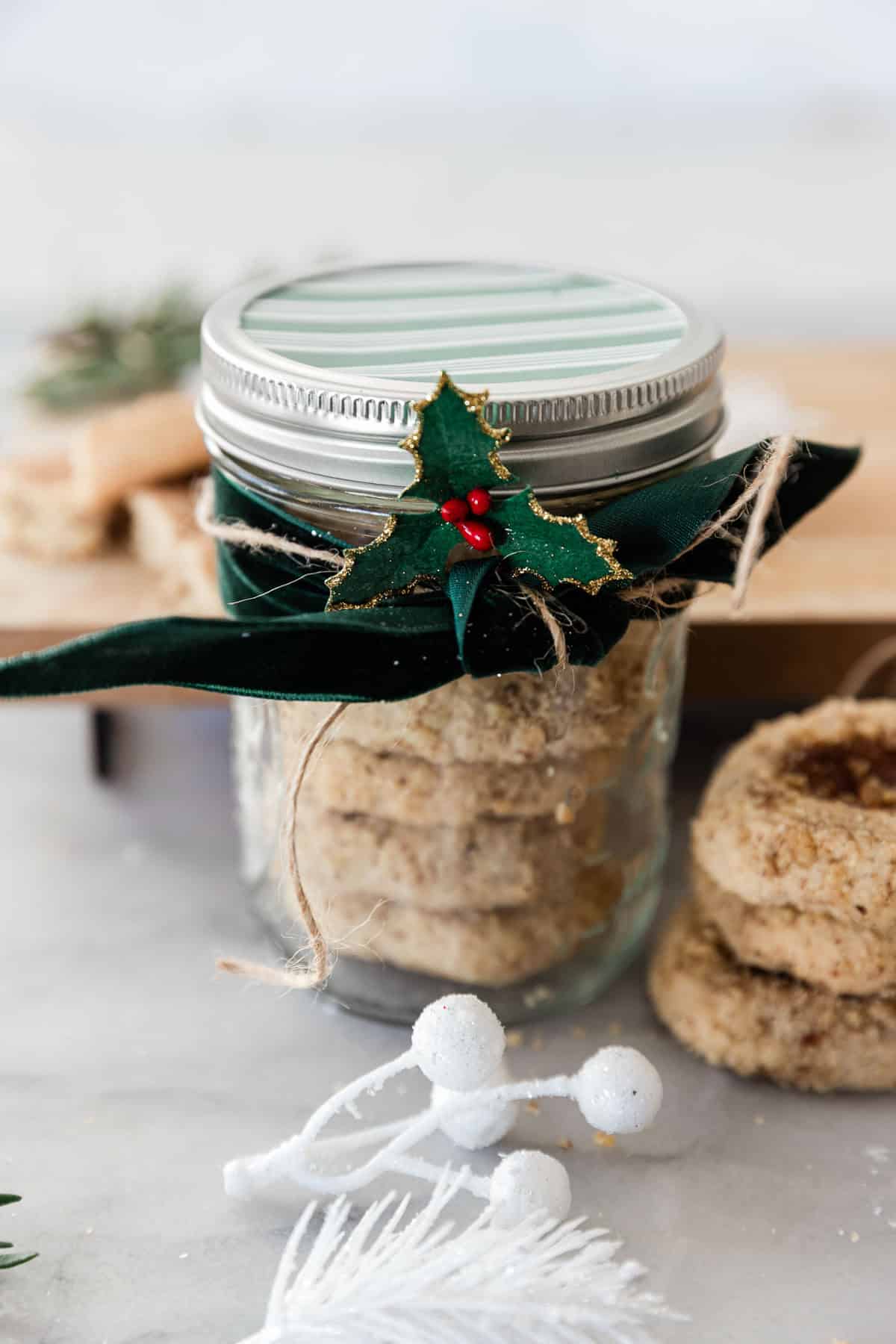 I am a big fan of pretty packaging - I love to wrap presents and I am always a sucker for a makeup item in adorable packaging, so why not package up your cookies in an inexpensive, but adorable way? I promise the receiver will be delighted to receive something so darn cute...and delicious! || Oh So Delicioso #cookies #holidaygifts #ediblegifts #giftideas Cookies packaged in a mason jar for the holidays.