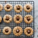 Baked peanut butter blossom cookie recipe on a cooling rack.