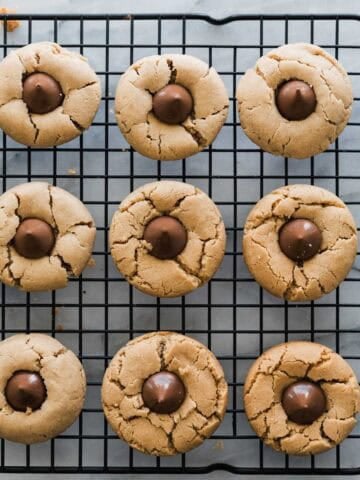 Baked peanut butter blossom cookie recipe on a cooling rack.