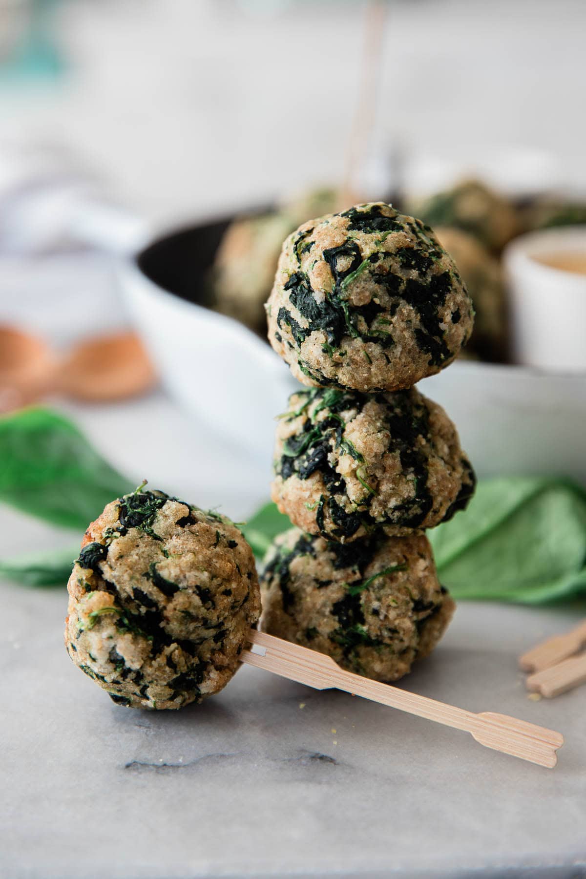 Spinach balls with dipping sauce in a skillet.