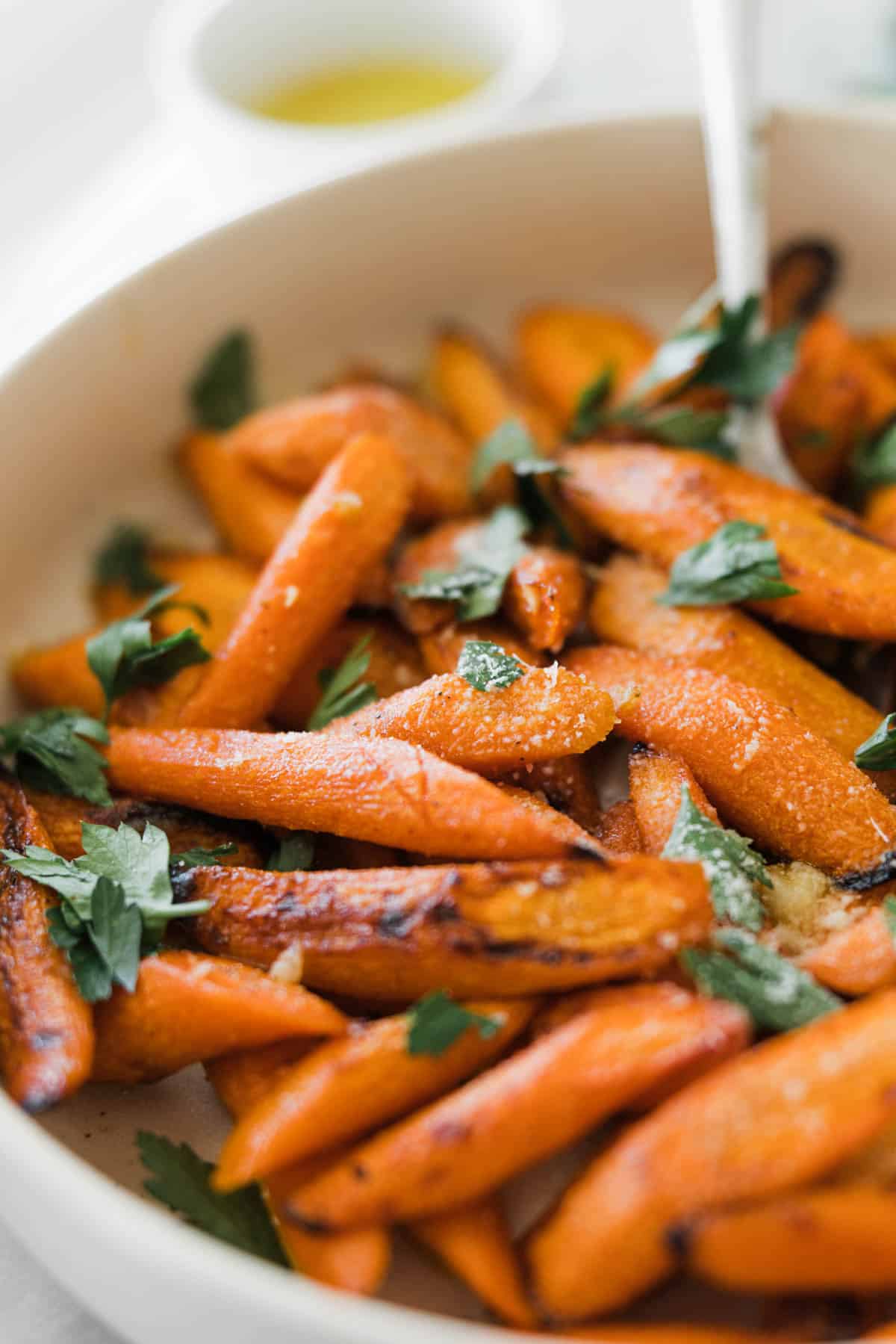 Honey glazed carrots in a serving dish garnished with parsley.
