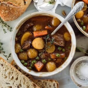 A bowl of homemade beef stew with a spoon resting in the dish.