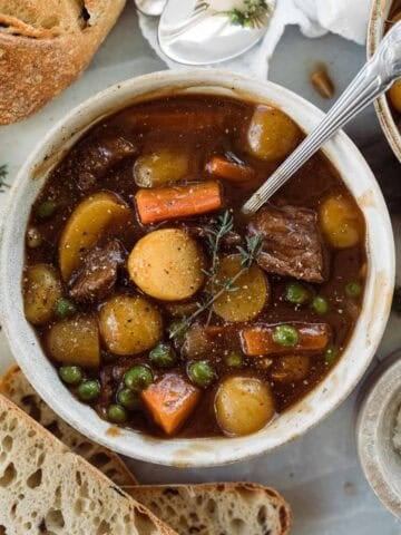 A bowl of homemade beef stew with a spoon resting in the dish.