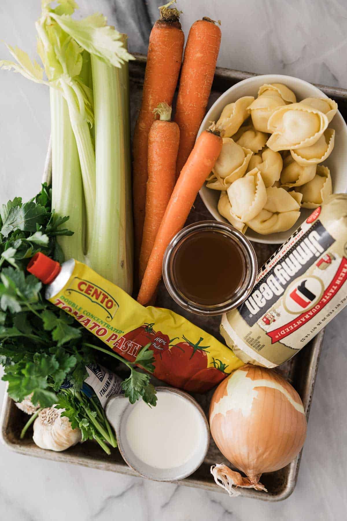 Ingredients to make sausage and tortellini soup on the table. 