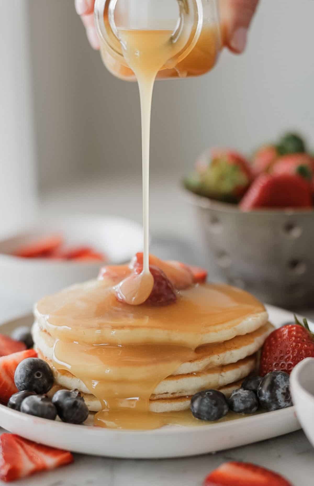 Coconut syrup poured over the top of a stack of pancakes.