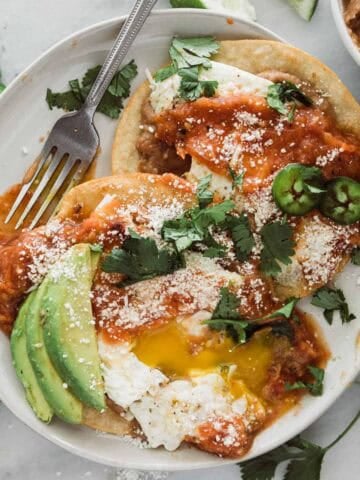 Easy huevos rancheros served on a white plate.