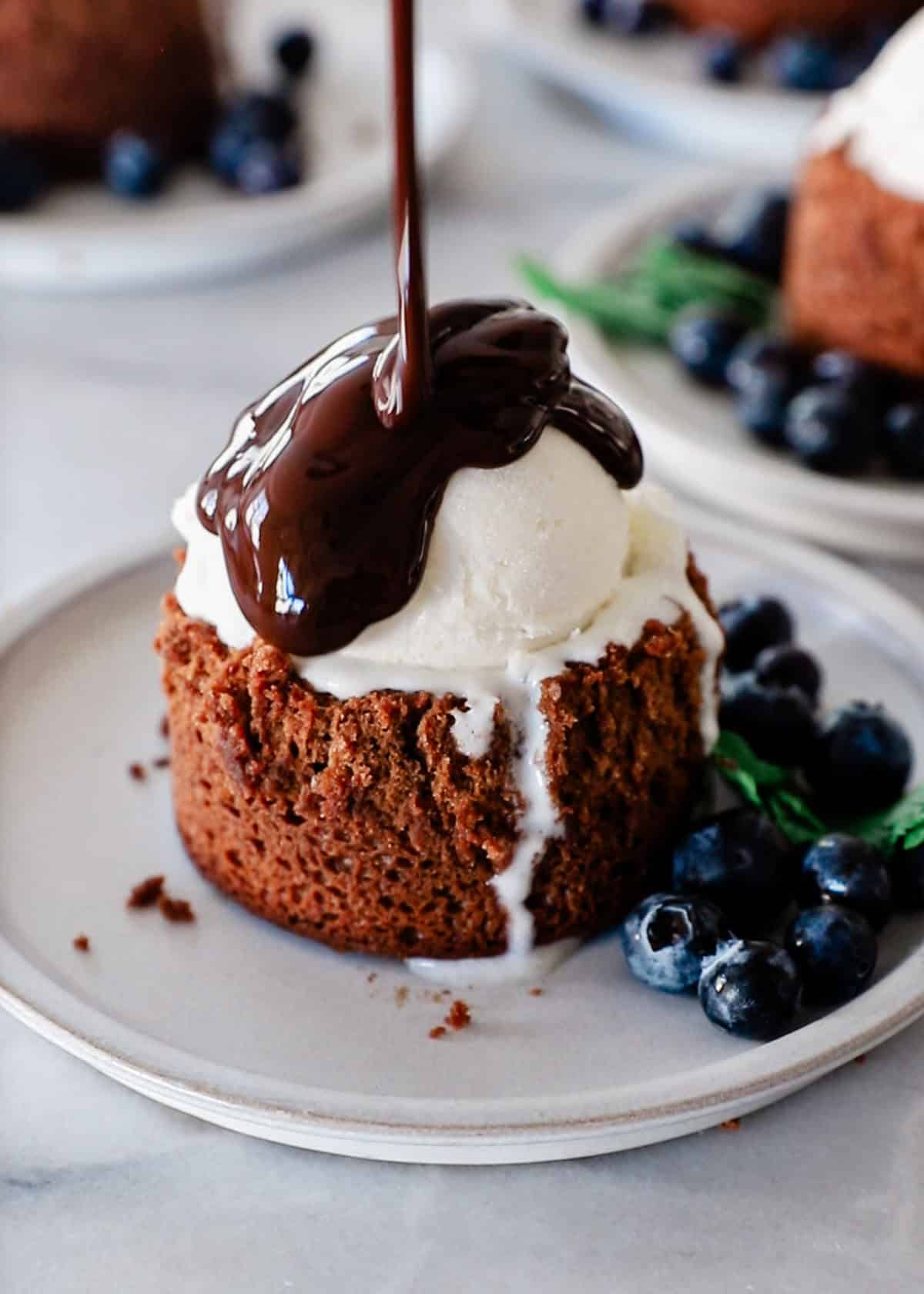 A chocolate lava cake with chocolate syrup drizzled on top.