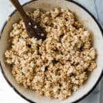 Salted caramel popcorn in a Dutch oven with a spoon in the pot.